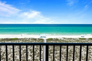 A beach view with a clear sky, a sandy shore, and a few people and boats. - 6 Bedroom | 7 King Beds | Elevator | Beachfront (Navarre)