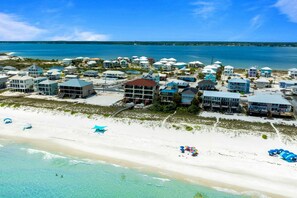 A coastal resort with beachfront villas, a sandy beach, and clear blue waters. - 6 Bedroom | 7 King Beds | Elevator | Beachfront (Navarre)