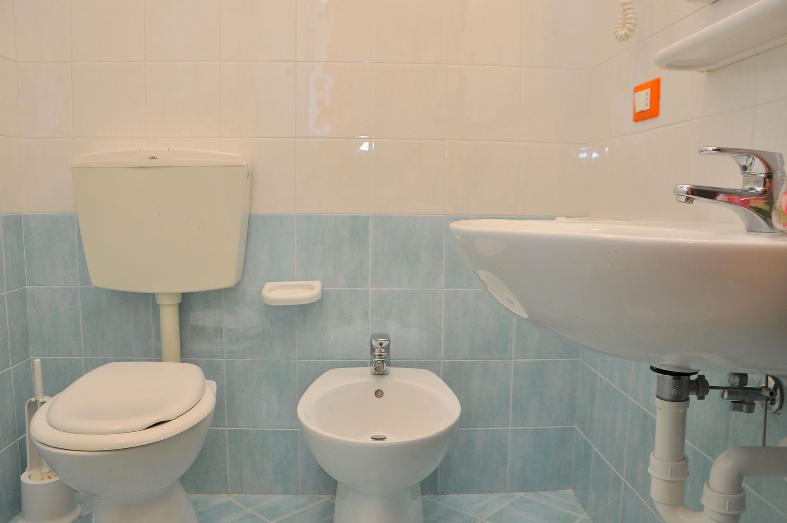 A bathroom with a toilet, bidet, and sink.