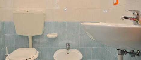 A bathroom with a toilet, bidet, and sink.