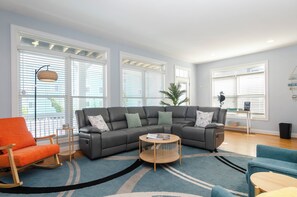 A living room with a sectional sofa, a rocking chair, and a coffee table.
