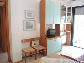A room with a television, two chairs, a table, and a cabinet. - One-bedroom flat next to Bibione Thermae (Bibione)