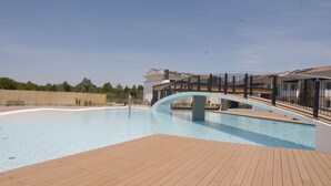 A swimming pool with a wooden deck and a bridge. - Homely flat with common pool and solarium (Bibione)
