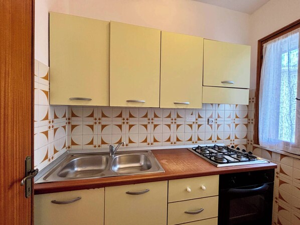 Una cocina con dos lavabos, una estufa y armarios.