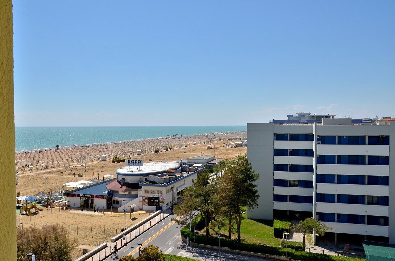 A coastal hotel with a beach view, a gas station, and a multi-story building.