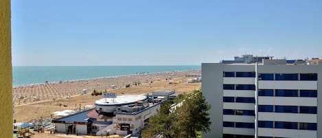 Ein Hotel an der Küste mit Blick auf den Strand, einer Tankstelle und einem mehrstöckigen Gebäude.