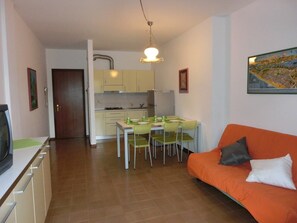 Un espace de vie compact comprenant un coin repas, une kitchenette et un canapé.
