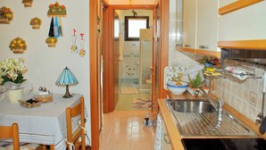 Eine Küche mit Spüle, Tisch und Stühlen sowie einem Fenster.