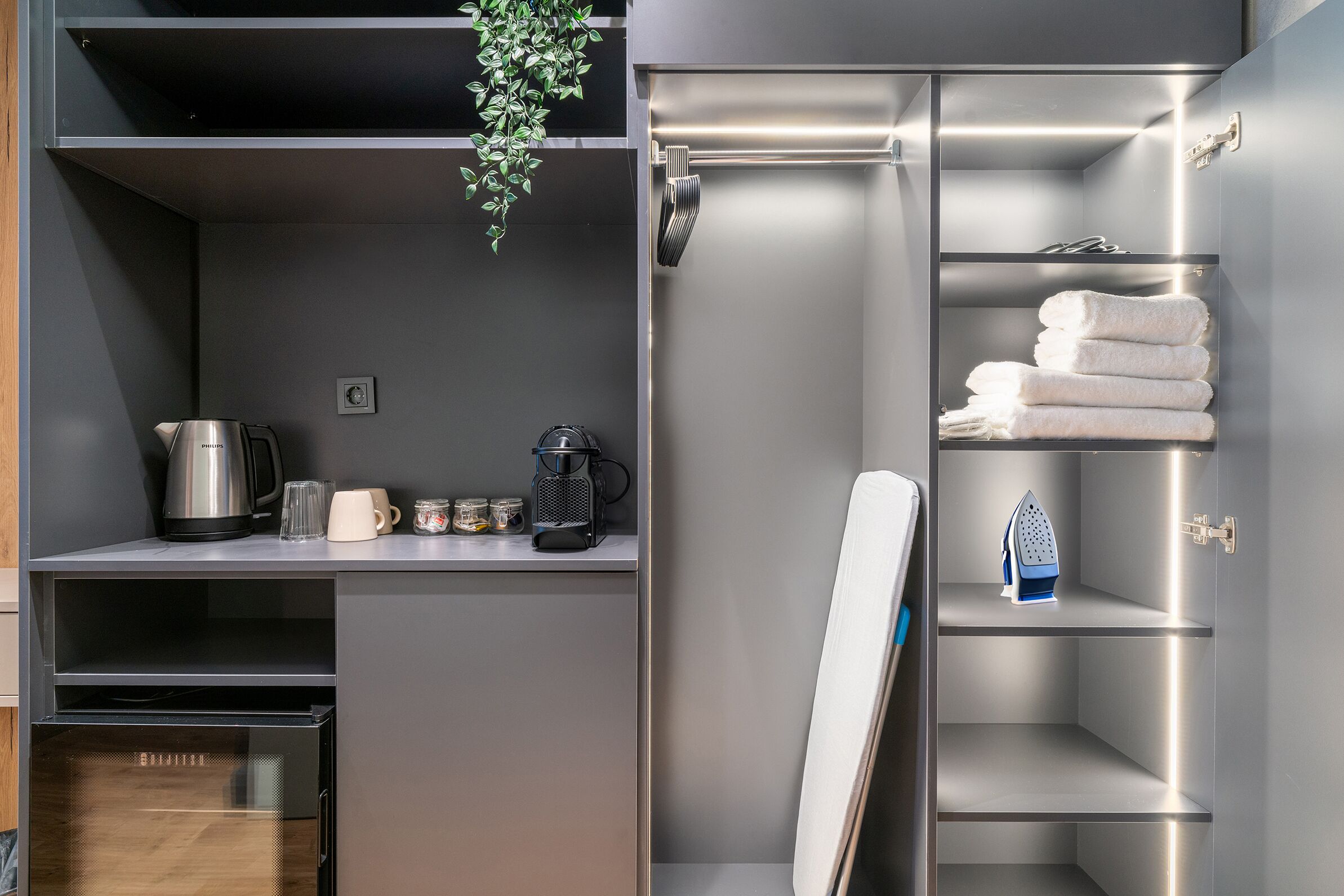 A modern kitchen with a kettle, coffee maker, and jars on the countertop.