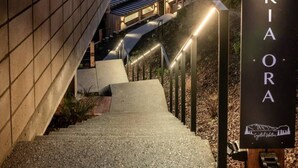 Uma escadaria leva a um edifício com uma placa que diz 'KIAORA'.