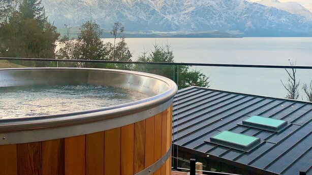A hot tub on a balcony with a view of mountains and a lake. - Crystal Waters- Suite 4 (Queenstown)
