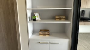 A white storage unit with two wooden crates labeled 'STORAGE' and a framed picture on the top shelf. - La casita Hua Hin (Hua Hin)