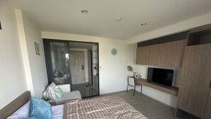 A modern hotel room with a bed, a desk, a TV, and a wardrobe. - La casita Hua Hin (Hua Hin)