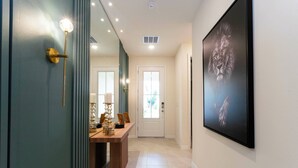 A hallway with a wooden table, a mirror, and a framed picture on the wall. - Relax & Play: Spacious Themed Retreat in Solara (Kissimmee)