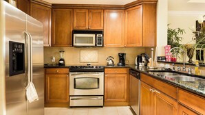 A kitchen with wooden cabinets, stainless steel appliances, a microwave, a stove, and a sink. - Serenity Apt - Tranquil and Cozy Orlando Apartment (Kissimmee)