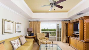 A spacious living room with a ceiling fan, a sofa, a coffee table, and a television. - Serenity Apt - Tranquil and Cozy Orlando Apartment (Kissimmee)