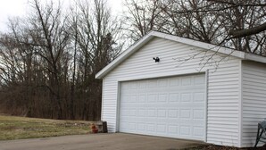 A single-story garage with a white exterior and a garage door.