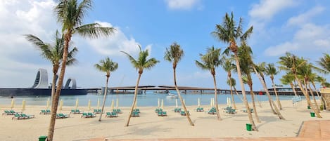 Plage, sable blanc, chaises longues, parasols