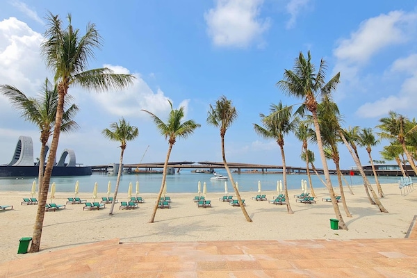 En la playa, playa de arena blanca, camastros y sombrillas