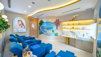 A modern spa area with blue seating, a mural, and a reception desk.