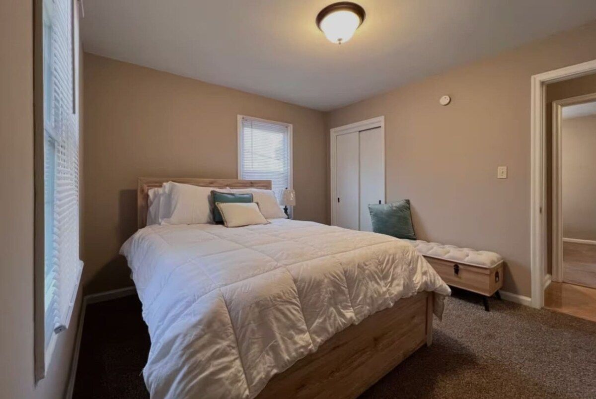 Une chambre à coucher avec un lit, une table de chevet et une commode.