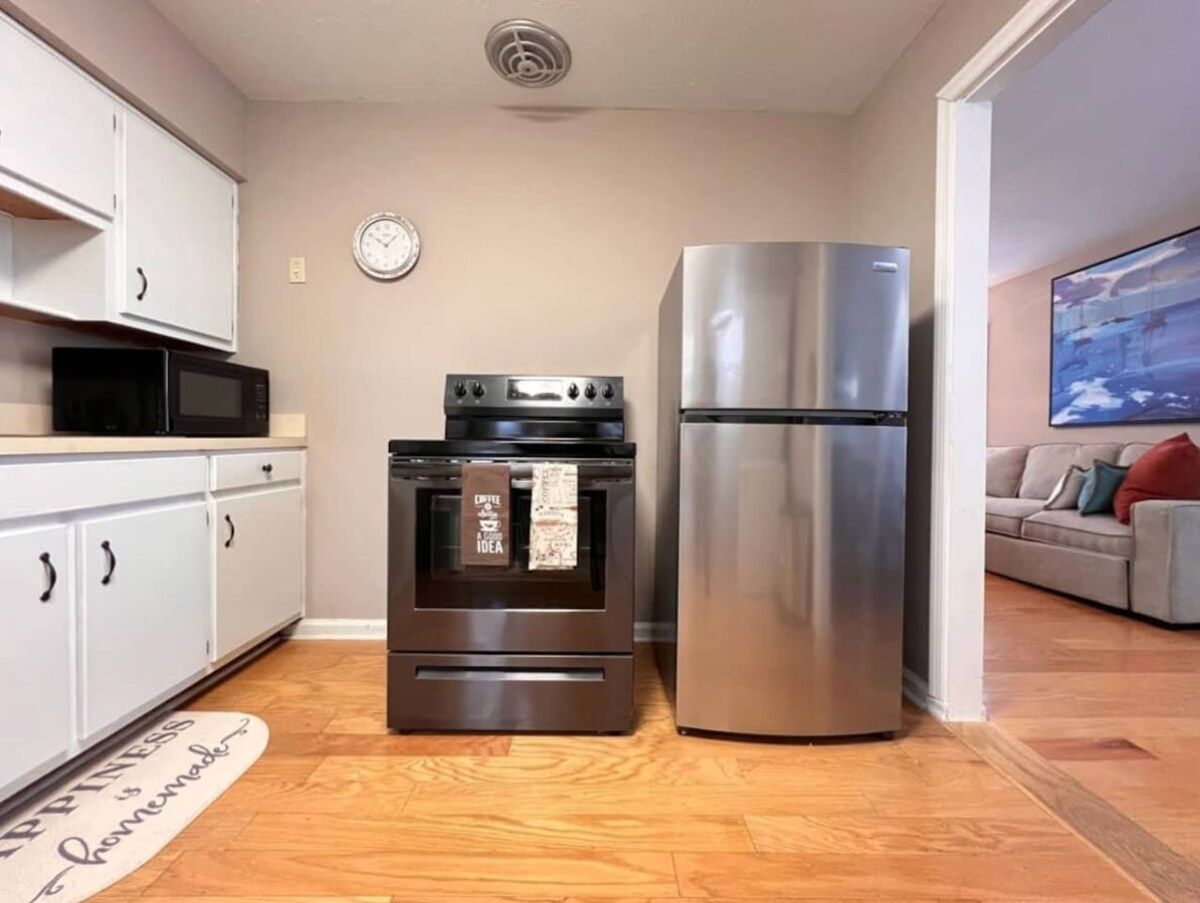 Eine kleine Küche mit eingebautem Backofen und einem Kühlschrank aus Edelstahl.