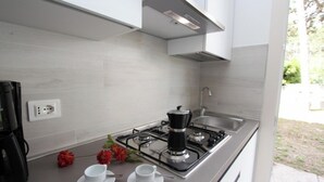 A modern kitchen with a gas stove, coffee maker, and a sink. - Wonderful villa with garden (Bibione)