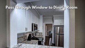 A kitchen with white cabinets, granite countertops, and stainless steel appliances. - 50s Retro residence in picturesque neighborhood (Jackson)