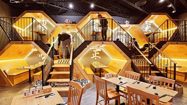 A restaurant with hexagonal wooden structures, wooden tables and chairs, and a staircase connecting different levels. - 50s Retro residence in picturesque neighborhood (Jackson)