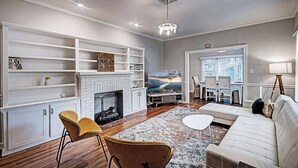 A living room with a fireplace, white shelving, a sofa, and a TV. - 50s Retro residence in picturesque neighborhood (Jackson)