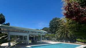 Une piscine agrémentée d’une pergola et d’une terrasse en briques.