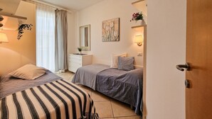 Un dormitorio con dos camas, un tocador, un espejo, un cuadro y una puerta.