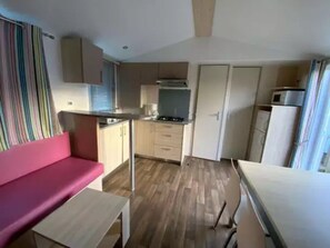 Uma cozinha compacta com área de jantar, kitchenette e um pequeno espaço para sentar.