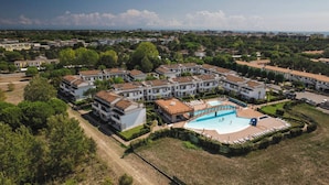 Ein Wohnkomplex mit mehreren Mehrfamilienhäusern, einem zentralen Schwimmbad und umliegender Grünfläche.
