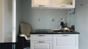 Una cucina moderna con mobili bianchi, un piano di lavoro nero e un lavello incassato.