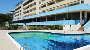 A multi-story hotel with a swimming pool. - Modern studio apartment with side sea view balcony (Bibione)