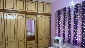 Un dormitorio con cama, armario y equipo de aire acondicionado.
