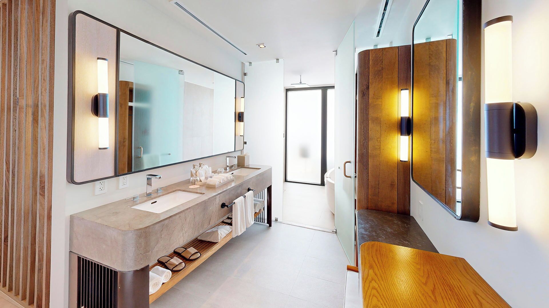 A modern bathroom with a large mirror, dual sinks, and built-in shelves.