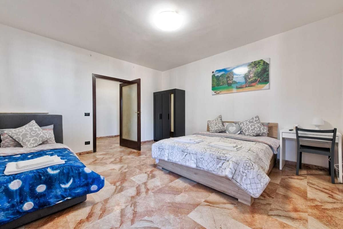 Ein Schlafzimmer mit Bett, Schreibtisch und Kleiderschrank.