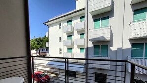A balcony with a view of a building with multiple balconies and windows. - Homely flat close to the beach (Caorle)