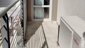 A balcony with a sliding glass door, a radiator, and a metal railing. - Homely flat close to the beach (Caorle)