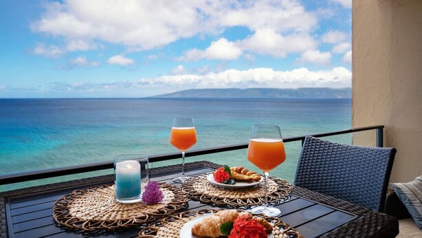 A balcony with a table set for breakfast, overlooking a clear blue sea and distant mountains. - ❤️Best Views on Maui! Perfect for Honeymooners!!❤️ (Lahaina)