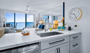 Een moderne keuken met een groot kookeiland, een spoelbak en uitzicht op de oceaan.