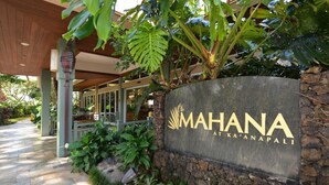 A stone wall with a sign for "MAHANA AT KA'ANAPALI" and a pathway leading to a building. - ❤️Best Views on Maui! Perfect for Honeymooners!!❤️ (Lahaina)