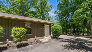 A single-story building with a garage, a small front yard, and a wooden fence.