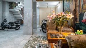 Um interior moderno com escada, área de estar e um mural decorativo na parede.