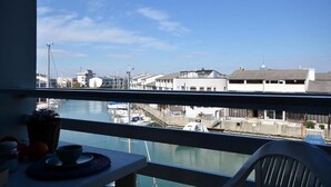 A balcony with a view of a marina, including boats and buildings. - Studio apartment near the sea in Lignano (Lignano Sabbiadoro)