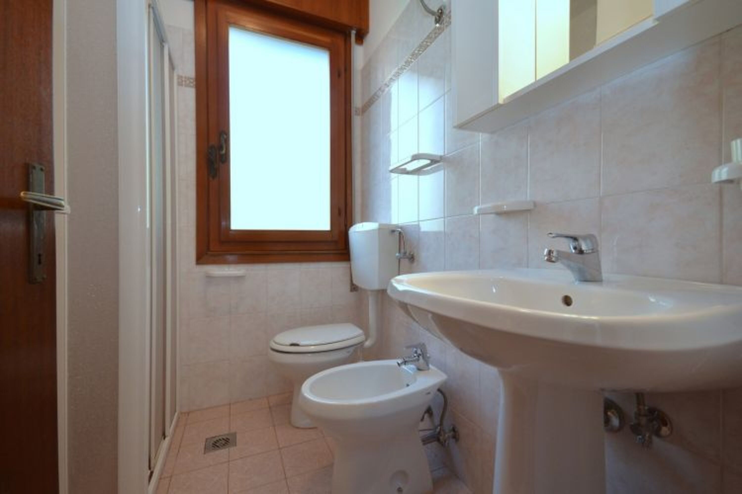 A bathroom with a toilet, bidet, and sink.