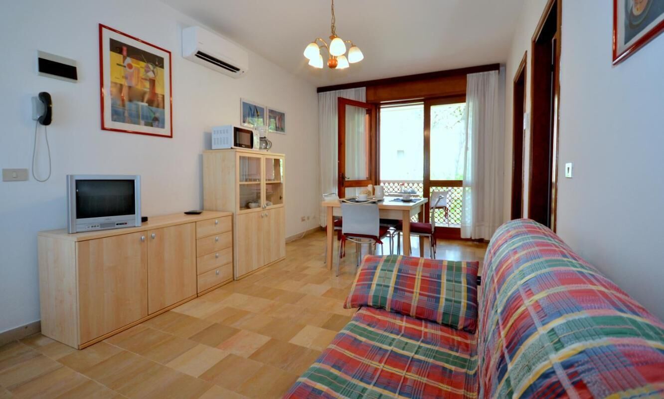 Een gezellige kamer met een bed, een bureau en een televisie.