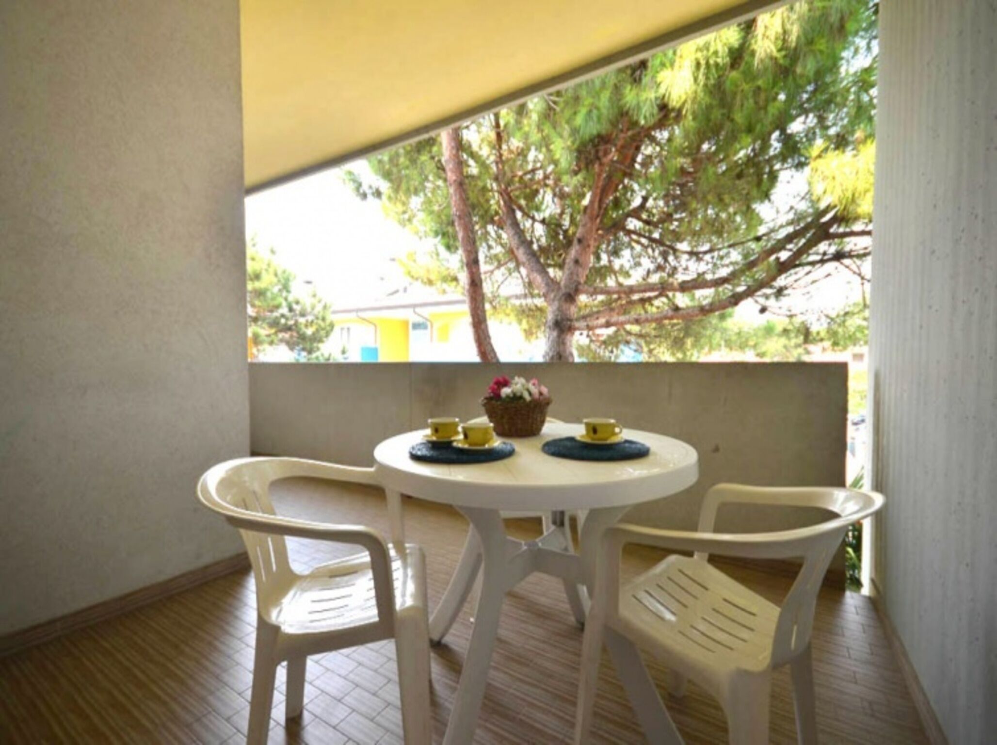 Un pequeño patio al aire libre con una mesa redonda y dos sillas.